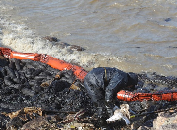 青岛环保工作者在大风中清理油污海上浮油已明显减少