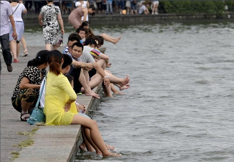 酷暑下游客贪凉快杭州西湖成了“洗脚池”